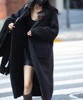 Long grey hooded knitted cardigan coat with trench coat style and loose fit.