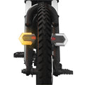 Black wireless bicycle turn signal set with remote control and USB charging cable on a bike frame