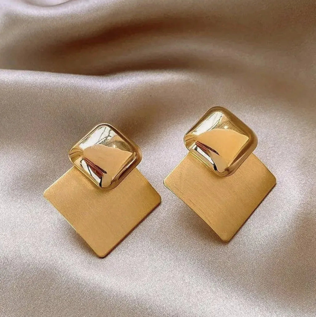 Women's gold brushed square stud earrings with 925 silver needle posts on a light background