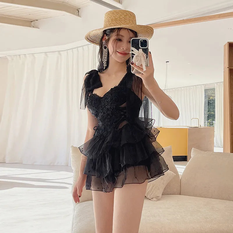 Black one-piece swimsuit with gathered chest detail on a mannequin