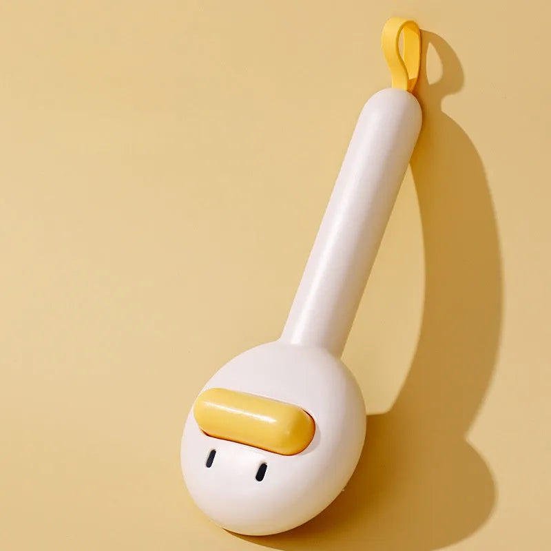 Small plastic pet comb with yellow duck design, showing open sections and floating needles for cat and dog grooming.