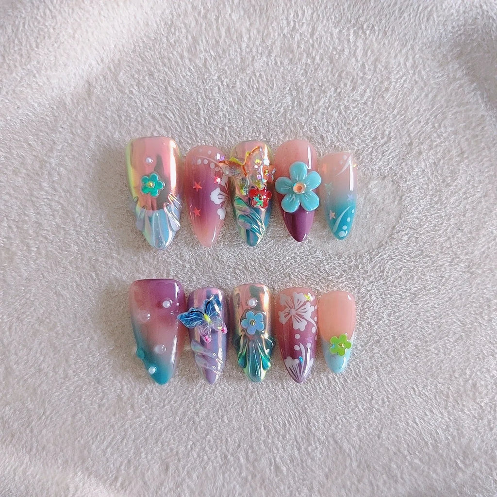 Handmade nail art sculptures with embossed floral and butterfly patterns in almond shapes