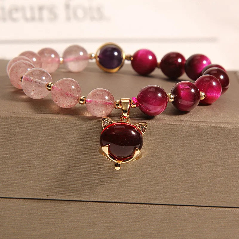 Simple women's bracelet with a strawberry crystal on a black elastic rope.
