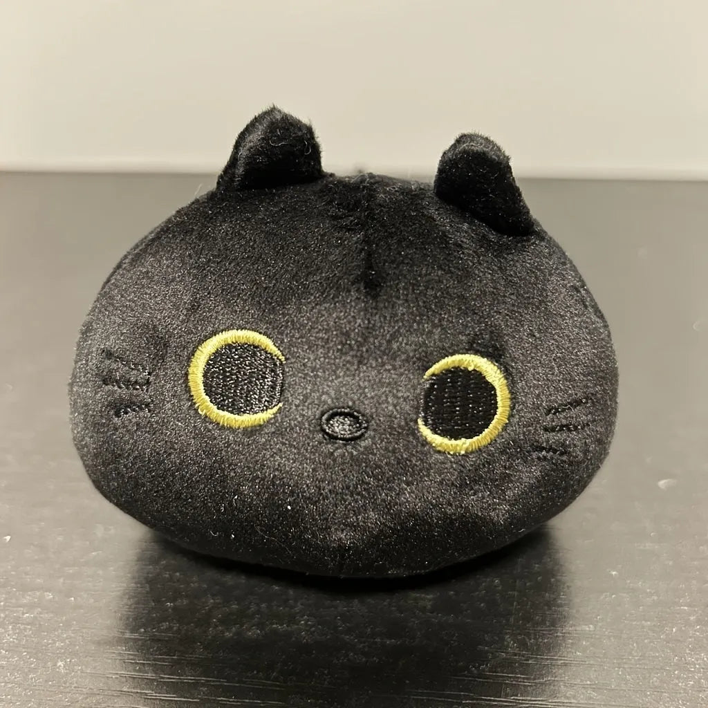 Fluffy black cat plush toy stuffed animal cushion on a sofa