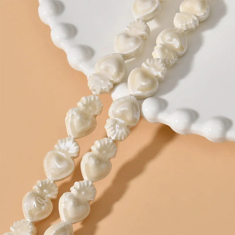 Assorted small ceramic torch beads in multiple colours on a white background.