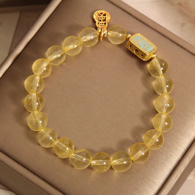 Women's citrine yellow crystal bracelet with rhinestone detailing on a wrist