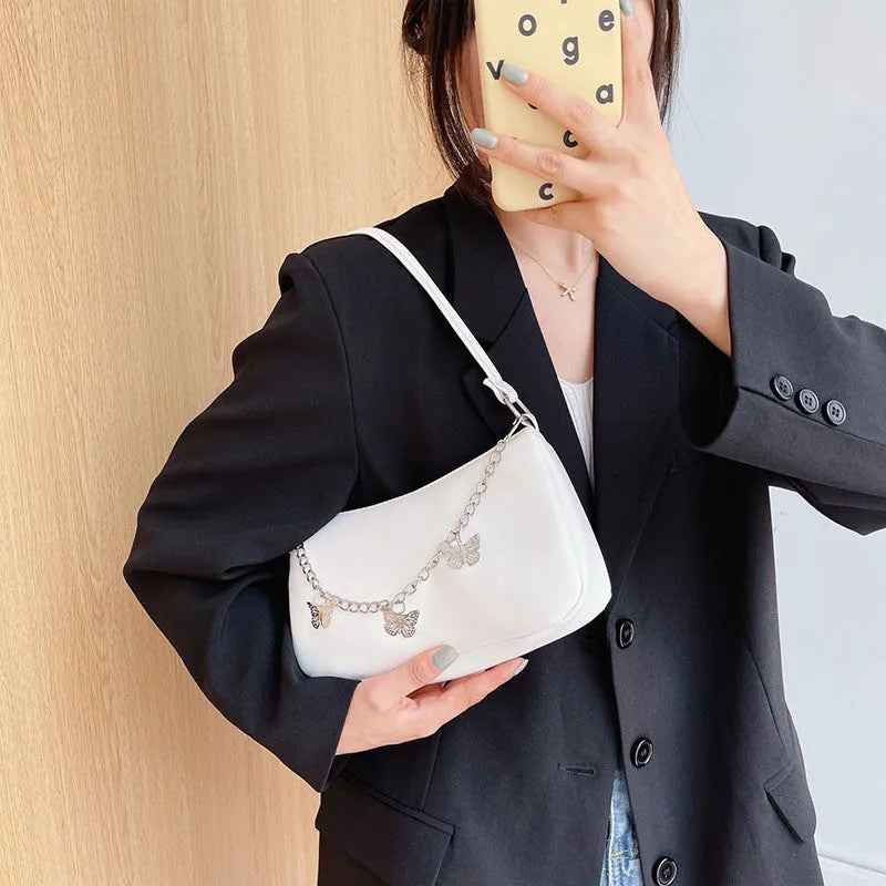 Black butterfly chain underarm bag with crossbody strap showing internal mobile phone and document compartments