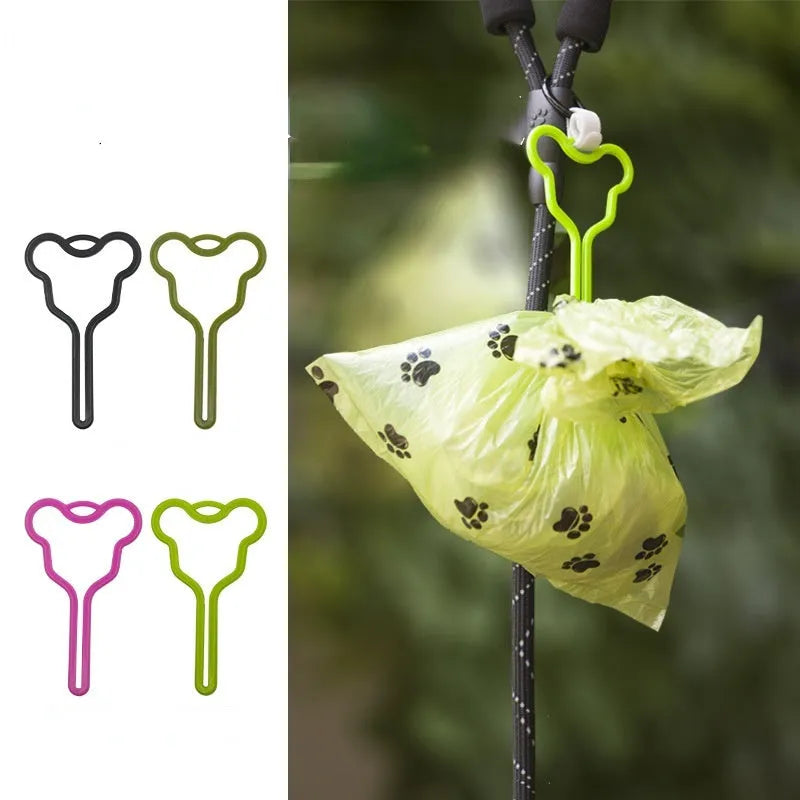 A hands-free dog waste bag holder with a fixed clip and adjustable Velcro strap attached to a pet leash.