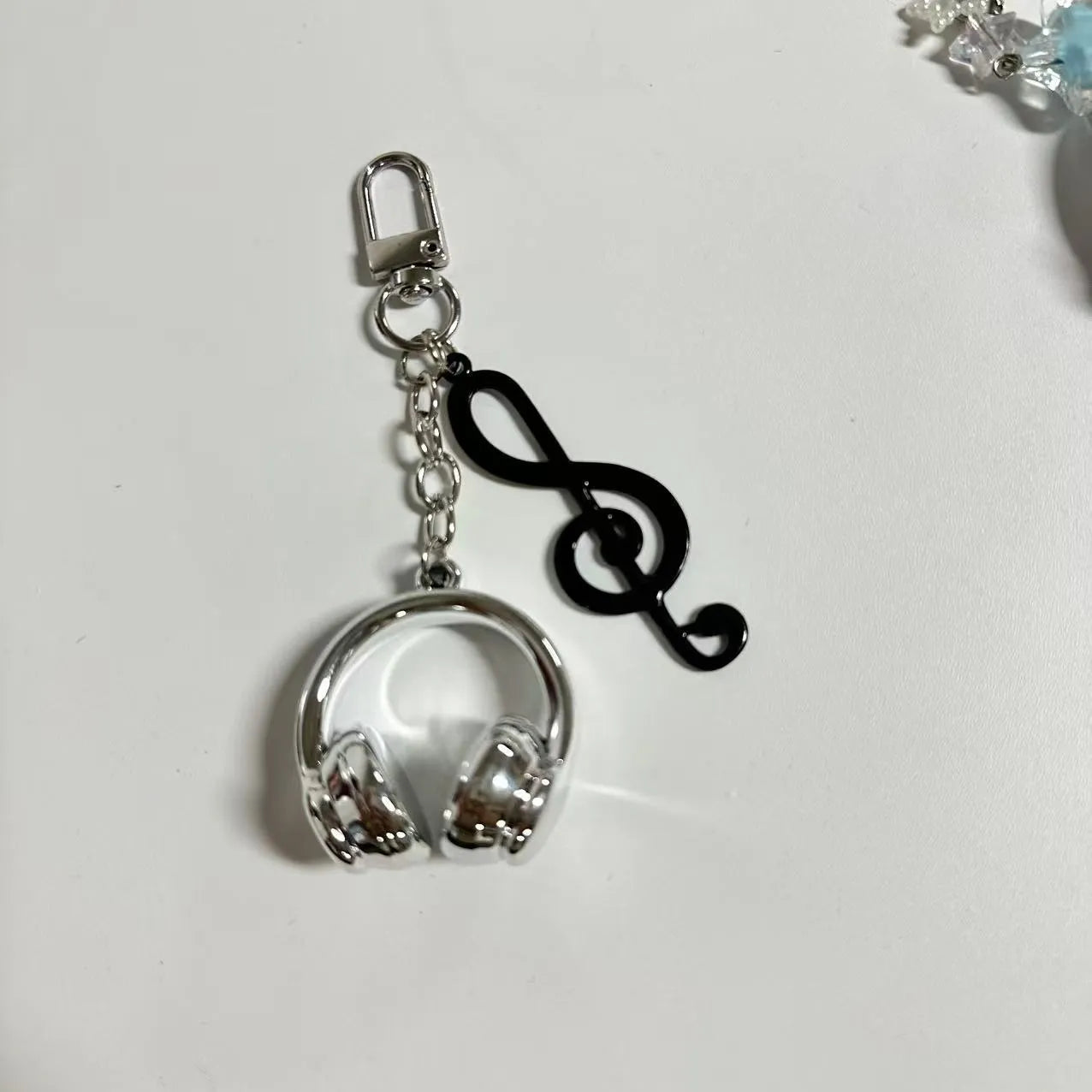Creative music headset keychain with gradient blue resin earphone pendant and alloy keyring on a plain background