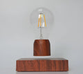 Magnetic levitation floating light bulb hovering above imitation wood base