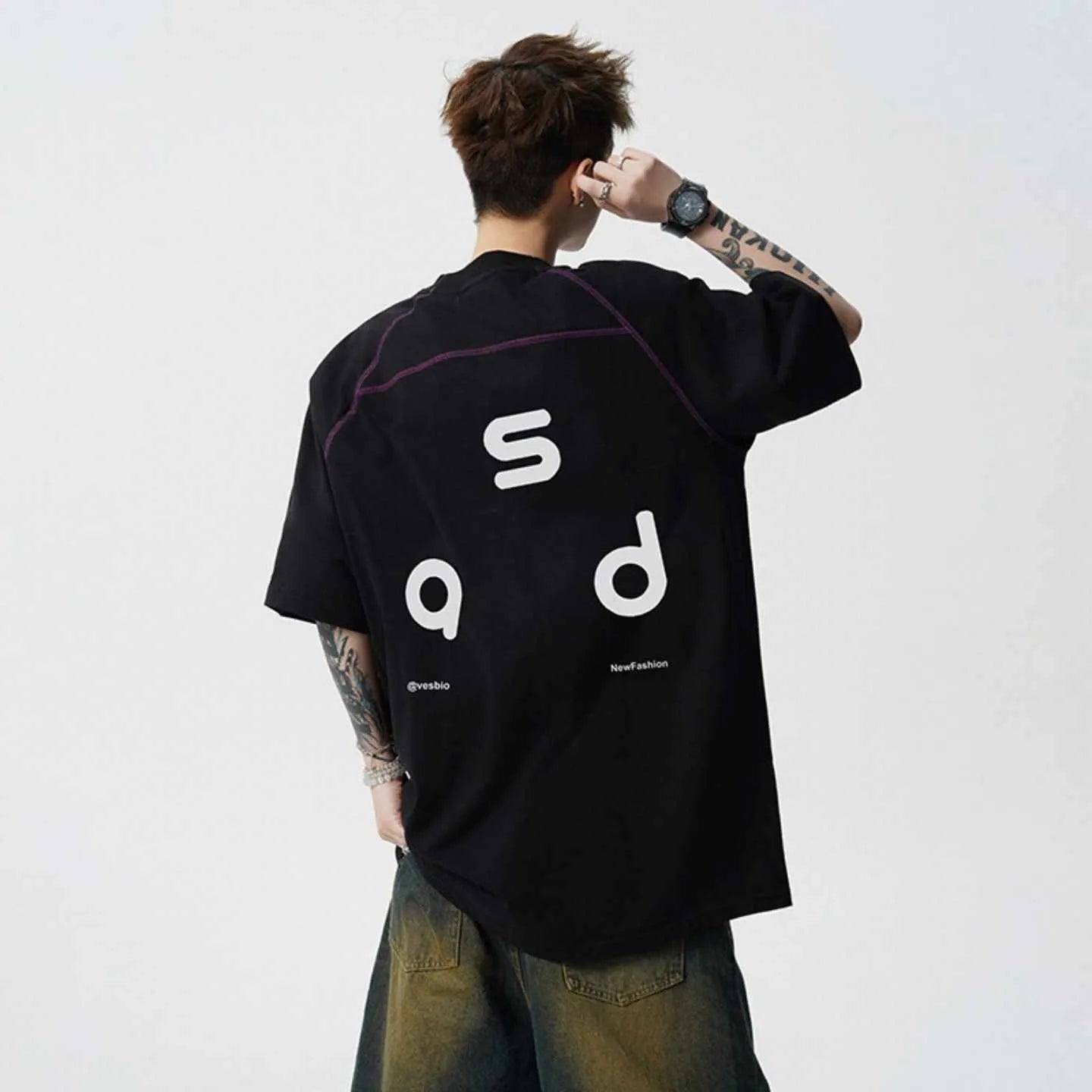 Men's loose-fit black cotton t-shirt with a white printed letter design on the front, showing short sleeves and a round neck.