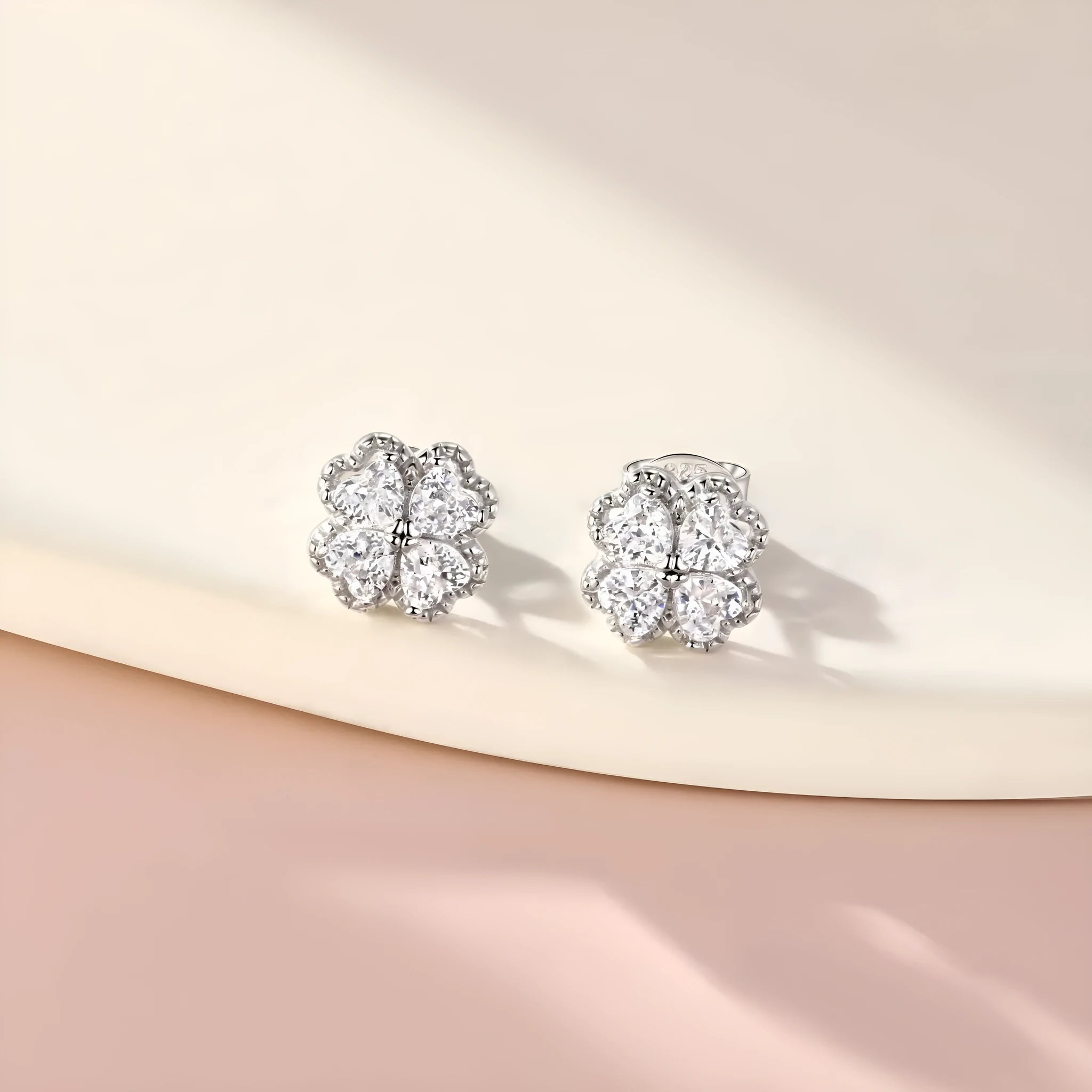 Pair of heart-shaped sterling silver earrings with four-leaf clover design and white gold colour finish.