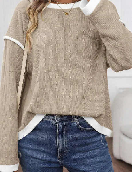 Women's loose grey knit top with green four leaf clover pattern trim on the sleeves and hem.