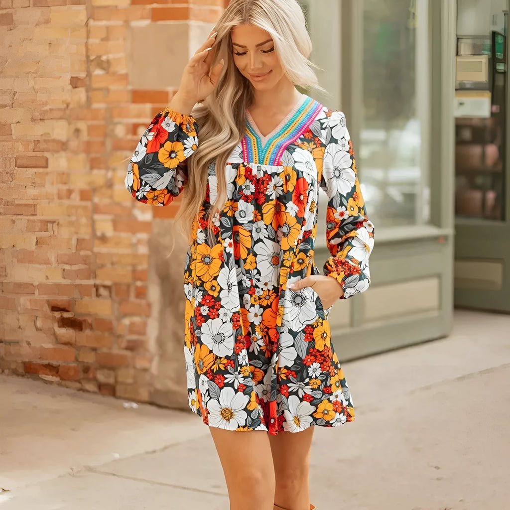 Orange floral print and striped lace V-neck long sleeve mini dress on a hanger.