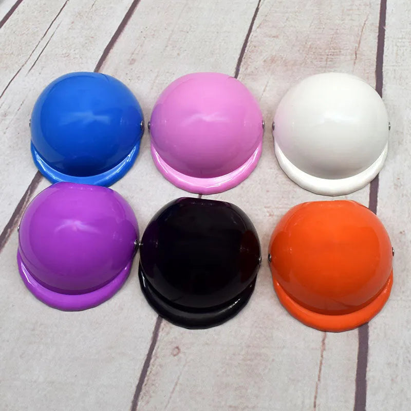 Plastic dog motorcycle helmet shown in multiple solid colours including pink, blue, and yellow, with size examples.