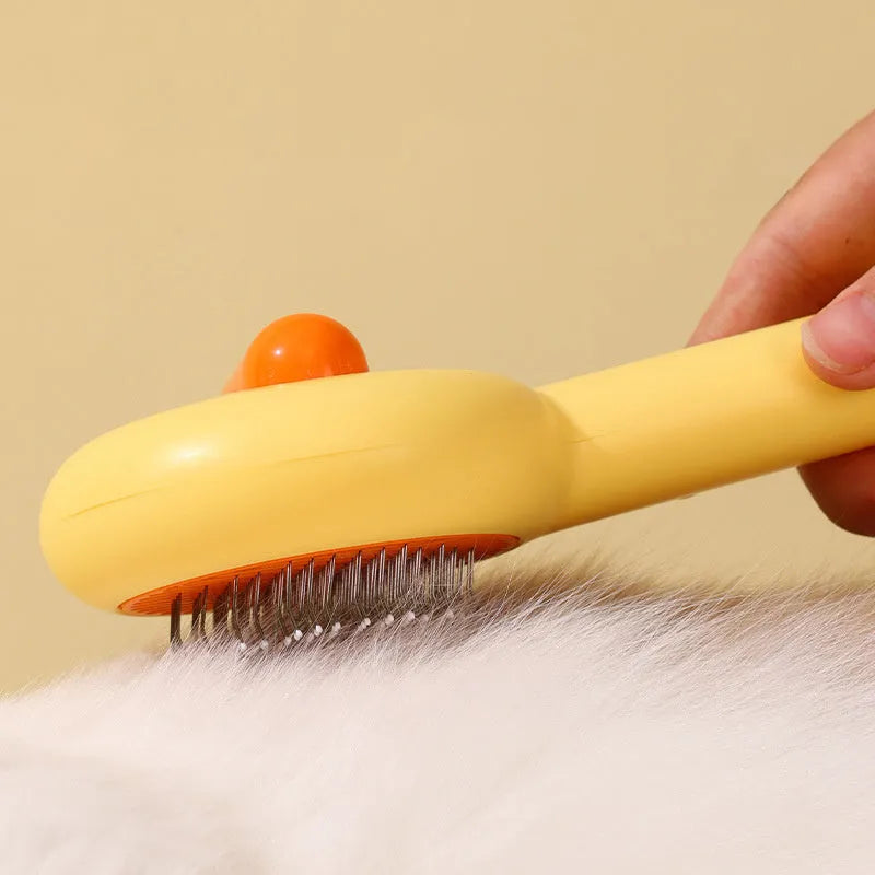 Small plastic pet comb with yellow duck design, showing open sections and floating needles for cat and dog grooming.