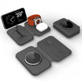 Folding magnetic three-in-one wireless charger in black with phone, watch, and earbuds on a desktop