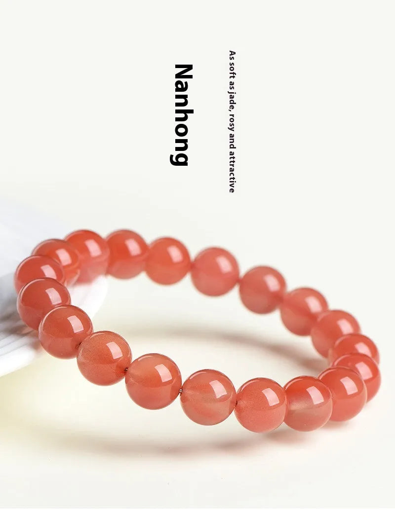 Natural South Cherry Red Agate polished bead bracelet shown in a scattered design on a wrist.