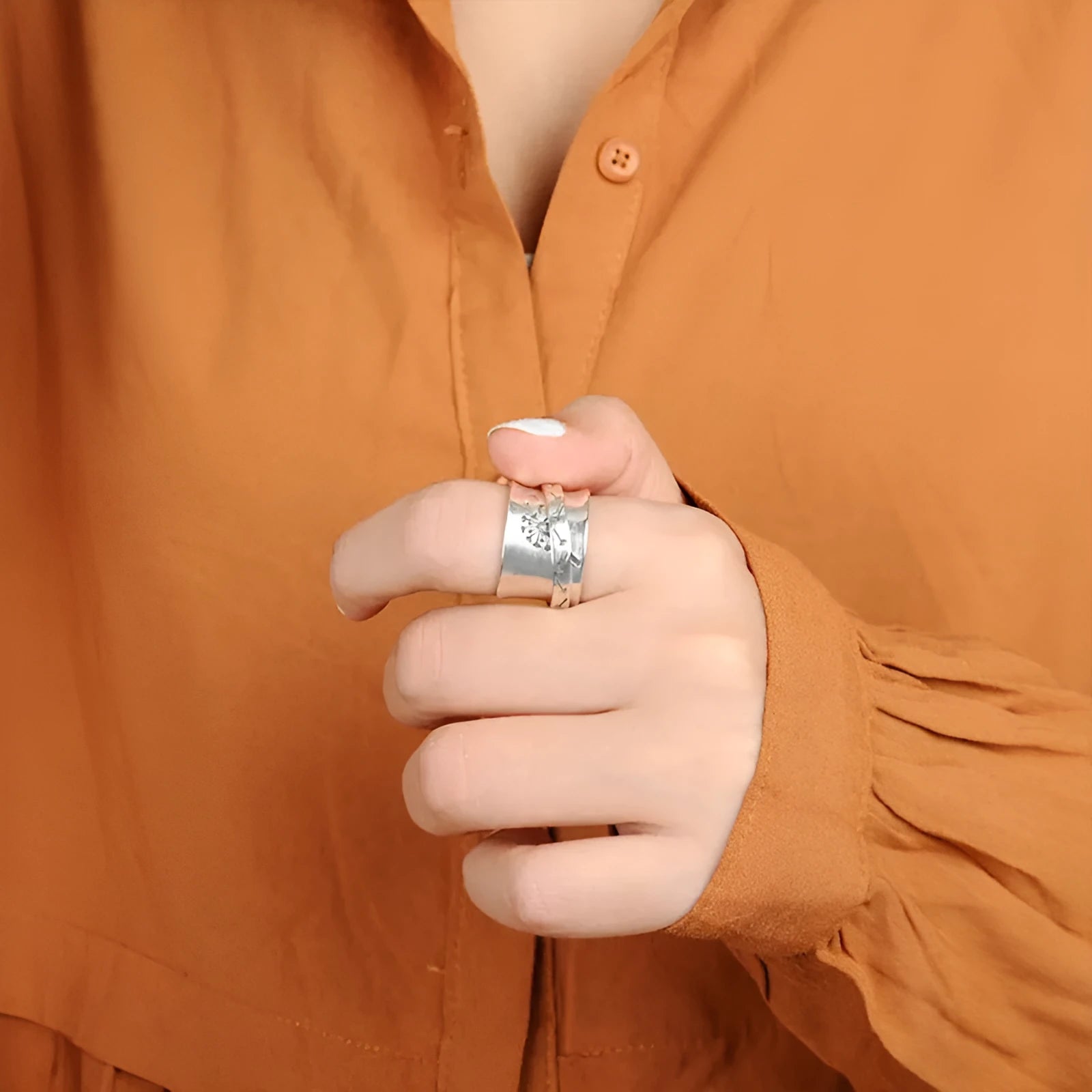 Silver-colour rotating flower ring showing floral element that moves independently of band