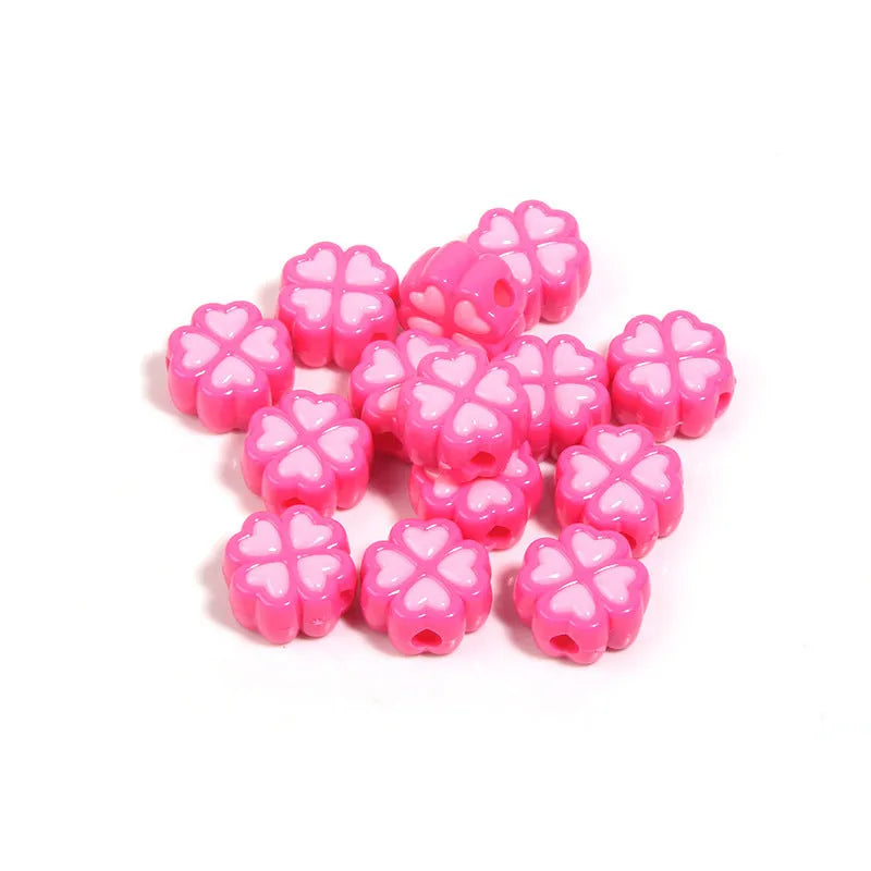 A selection of 15mm frosted acrylic beads showing a raised cartoon love and four-leaf clover pattern in various colours.