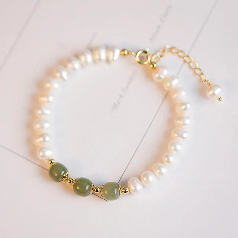 Korean style bracelet with diamond-shaped freshwater pearls in Hetian jade colour on a wrist.