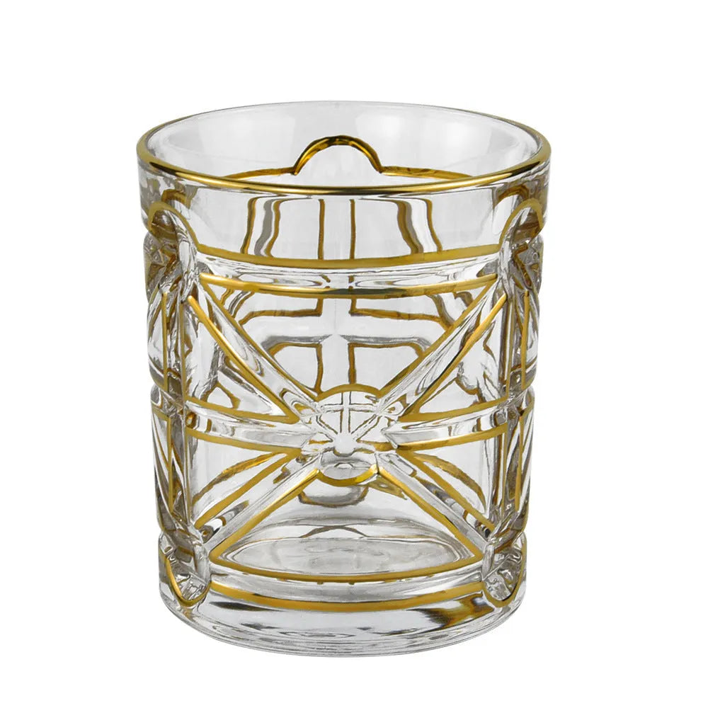 Crystal glass whiskey shot glass with solid gold finish on a bar counter