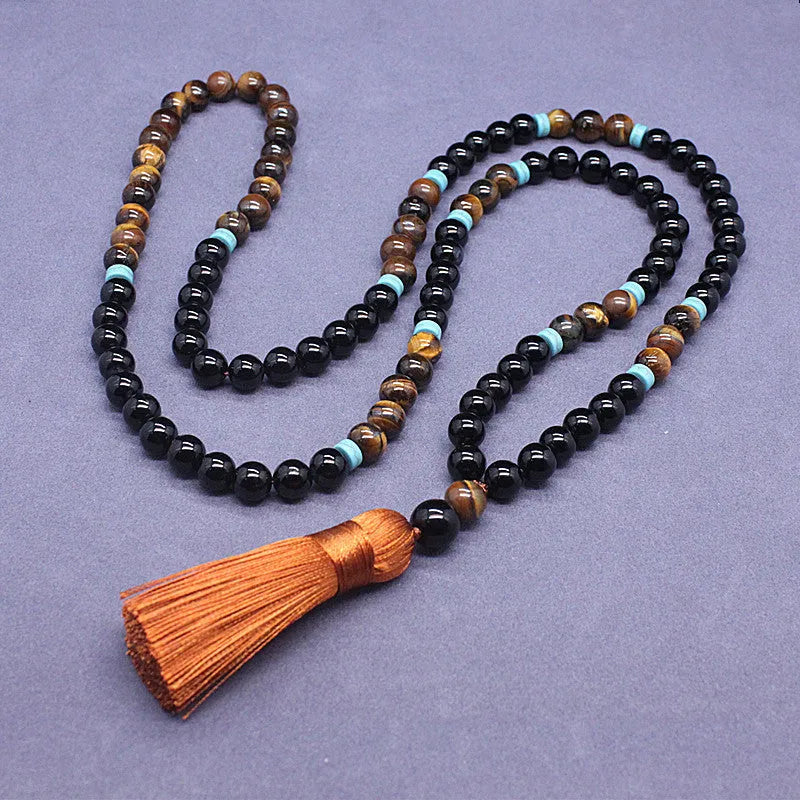 Black agate geometric bead bracelet and matching tiger-shaped tigereye stone necklace set on a grey background.