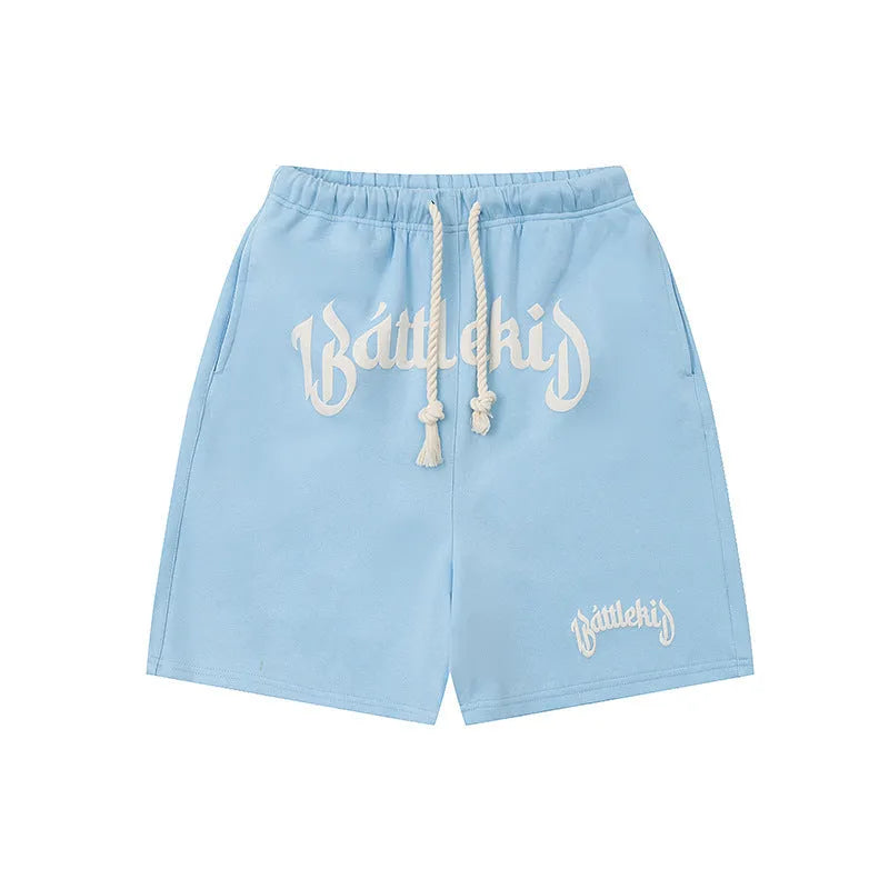 Men's loose grey cotton blend hip hop shorts with a cropped, street-style design on a neutral background.