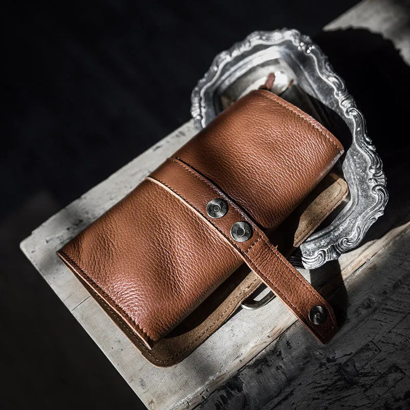 Handmade cow leather vintage wallet in black, showing tape extraction closure.