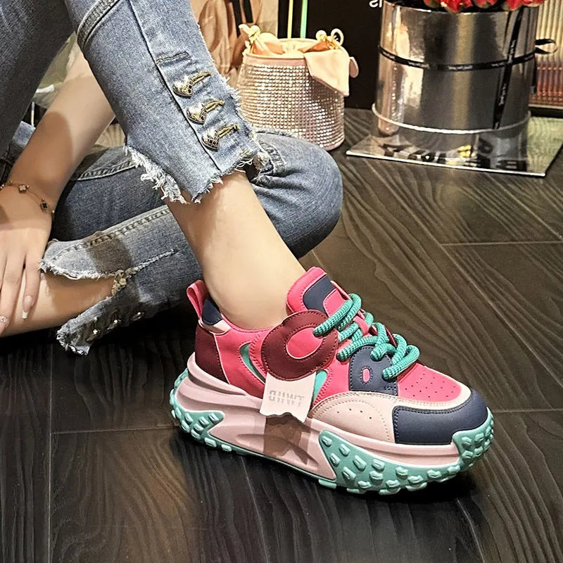A pair of leather casual shoes with a thick wedge sole, round toe, and front lace-up design.