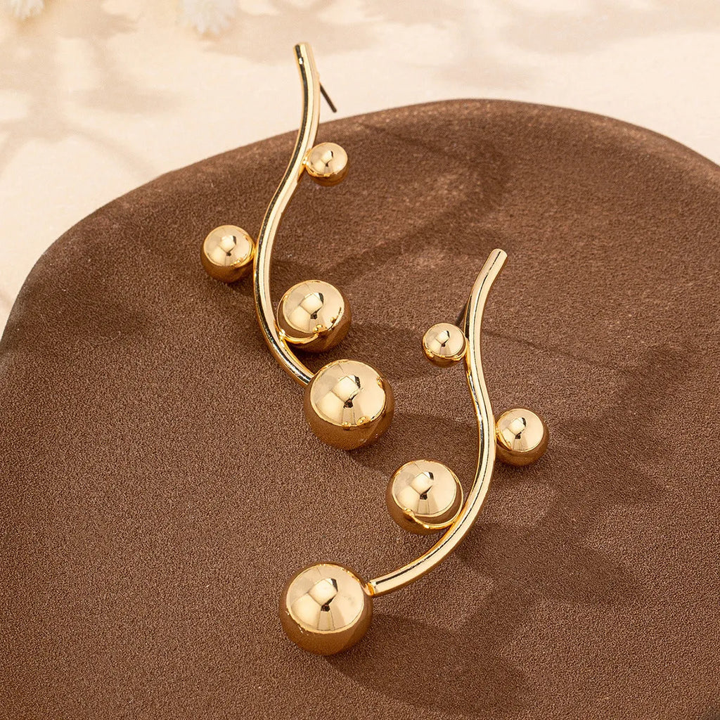 Golden yellow iron ball stud earrings with round shape on a white background