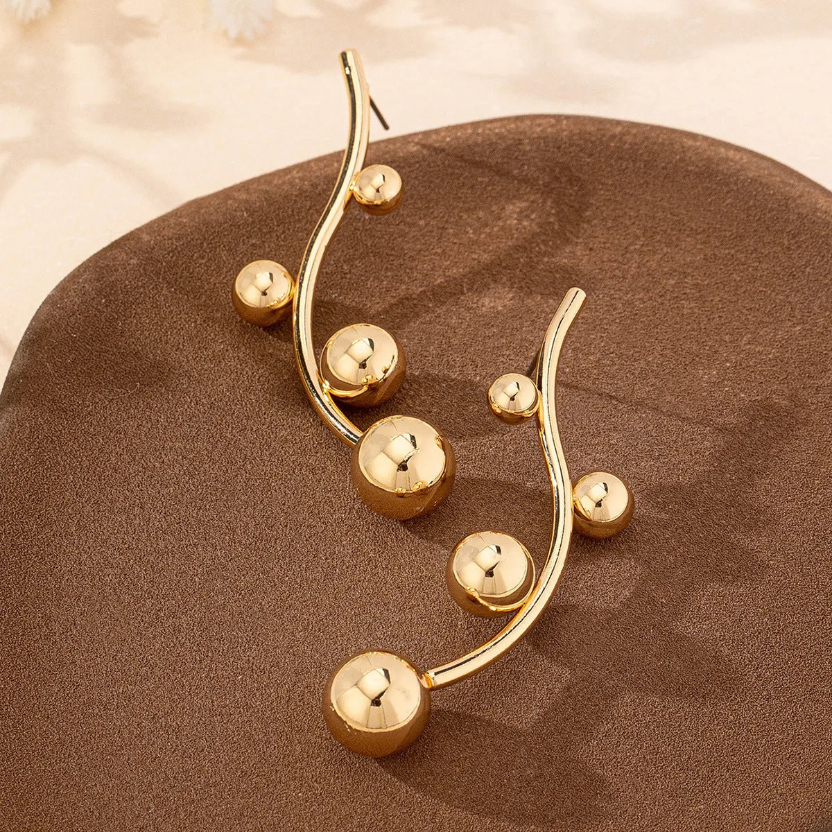 Golden yellow iron ball stud earrings with round shape on a white background