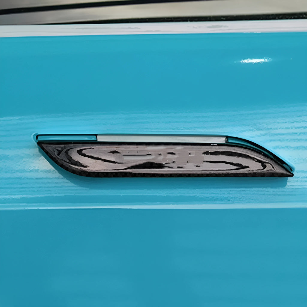 Four carbon fibre adhesive door handle protection patches for a Tesla Model S.