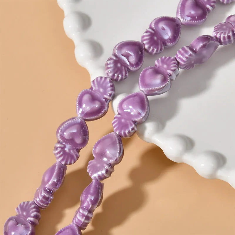 Assorted small ceramic torch beads in multiple colours on a white background.