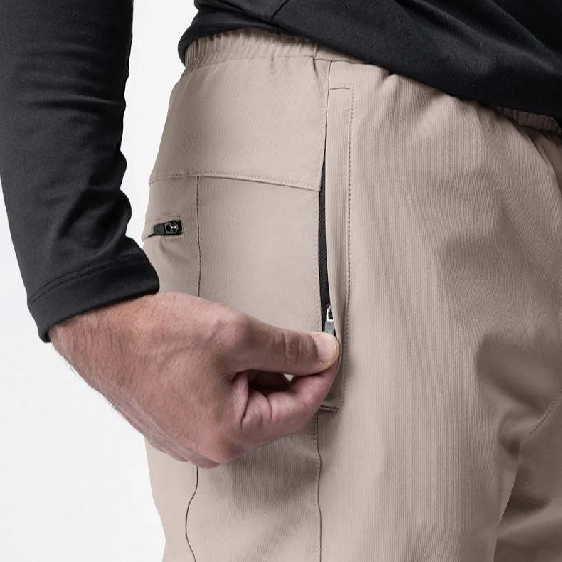 Man wearing dark grey loose-fit ankle-tied polyester running trousers for fitness.