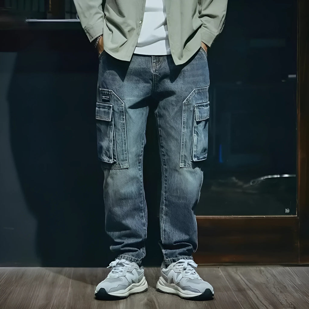 Blue men's loose straight-leg stretch jeans with a zip fly on a neutral background.