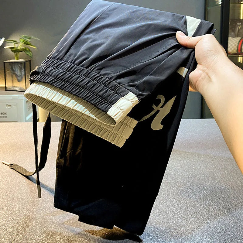 Man wearing black ultra-thin ice silk cropped trousers with elasticated ankle bands.