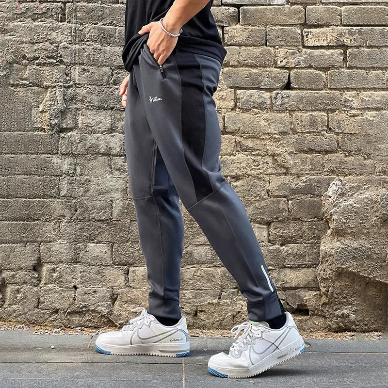 Men's deep gray stretch polyester sweatpants with panel zip pockets, side view