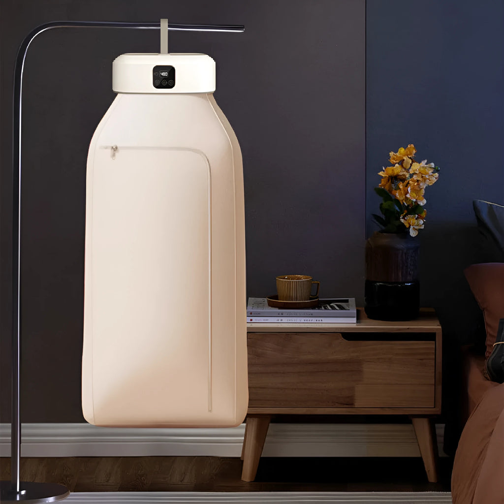 White cylindrical portable laundry drier with remote control on flat surface