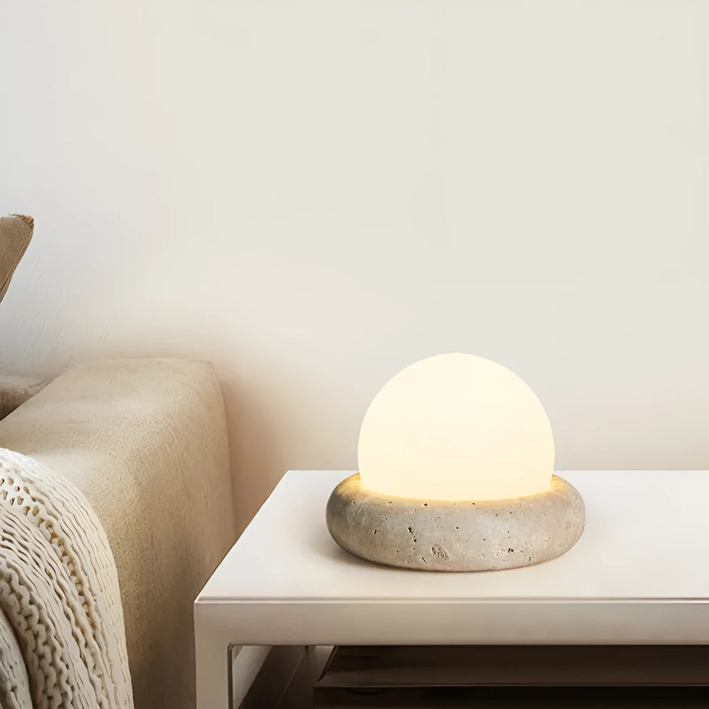 Cream coloured bedside night lamp with remote control on table