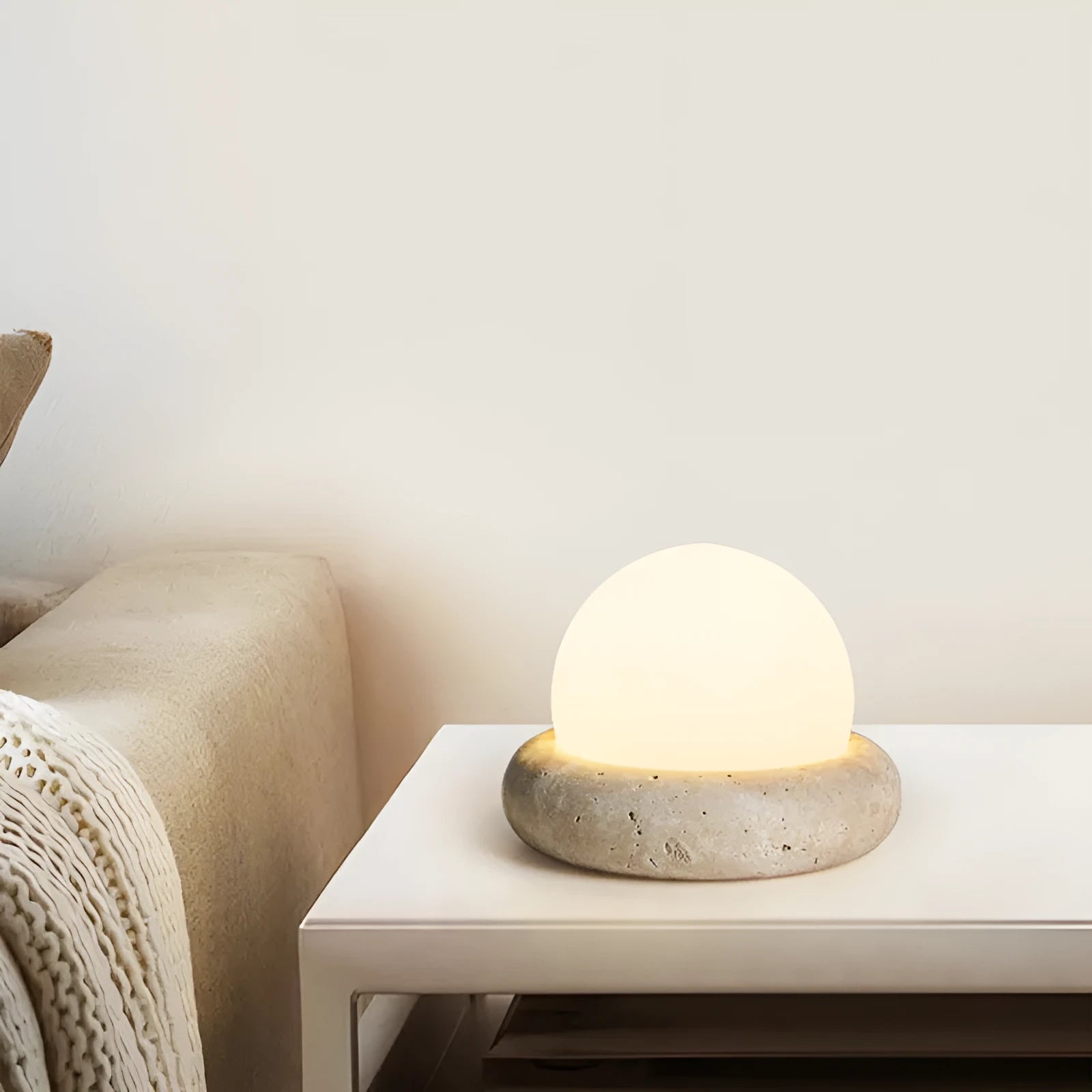 Cream coloured bedside night lamp with remote control on table