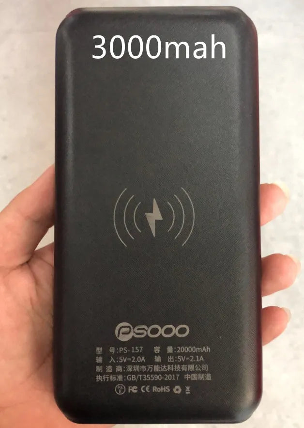 Black wireless power bank with Qi charging pad, three USB ports, and LED flashlight showing capacity display.