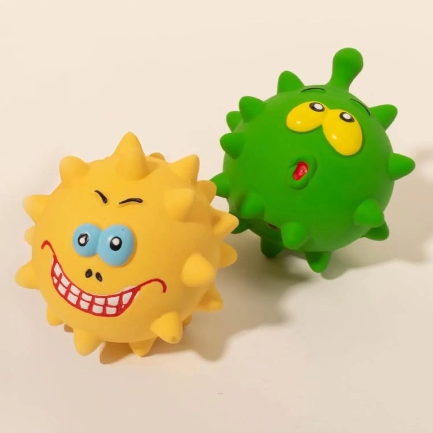 Four colourful latex squeaky dog balls with bumpy texture and cute faces for dental cleaning during play