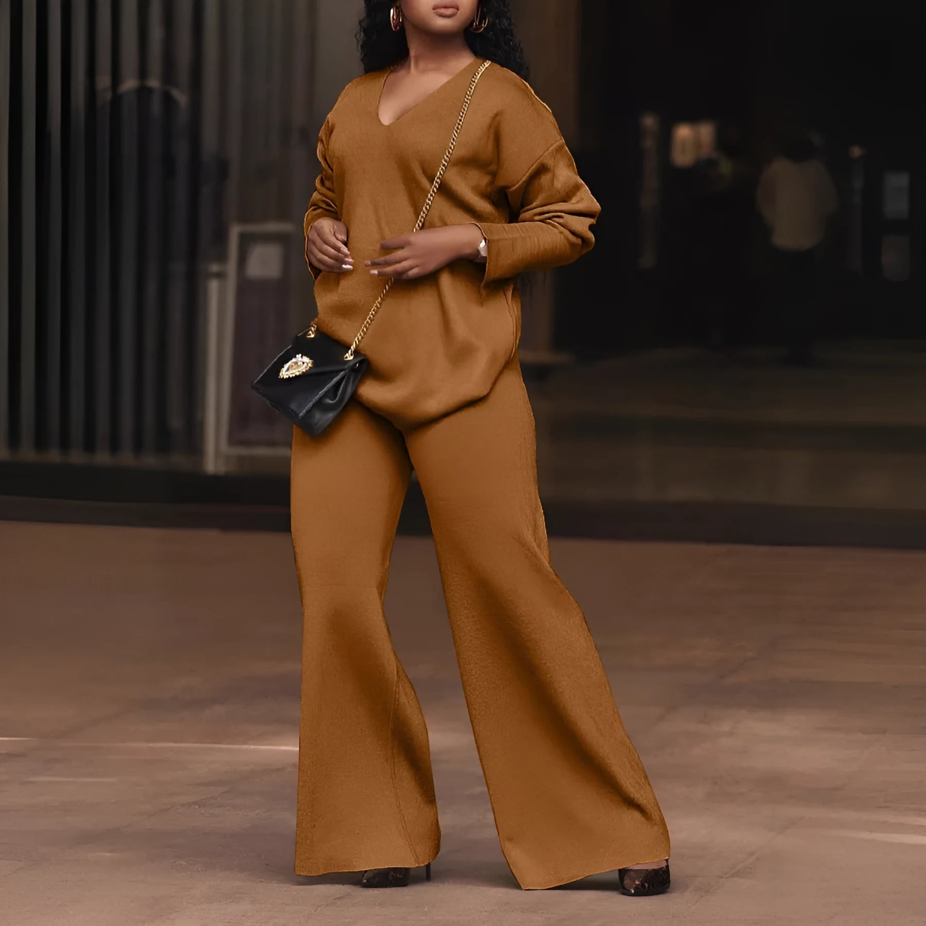 Women's brown suede two-piece casual suit with long sleeves and trousers on a hanger