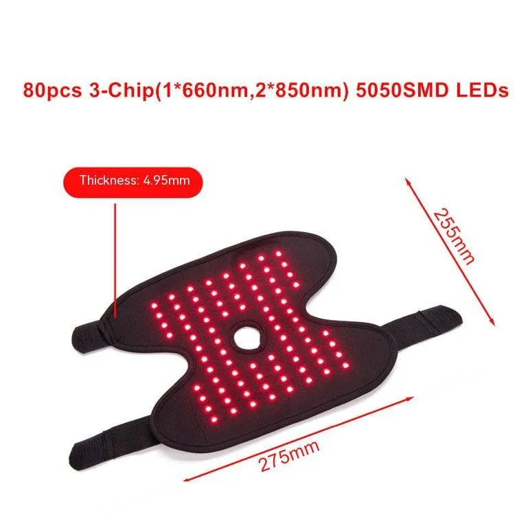 Black ankle heating wrap with red light therapy and USB cable on flat surface