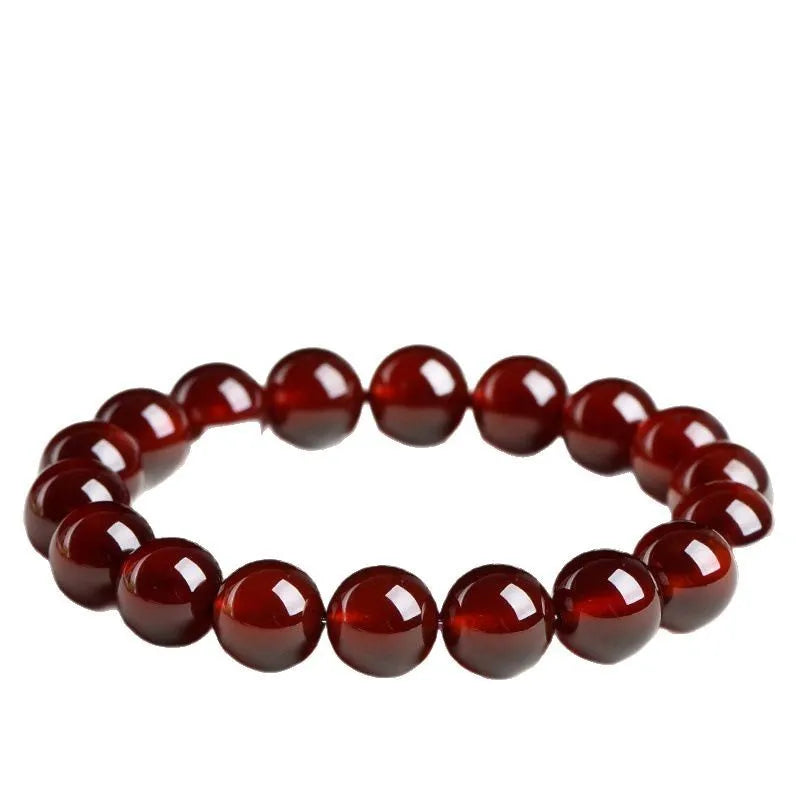 Natural orange red garnet ball bracelet with a silver Ruyi charm on a crystal beaded strand.
