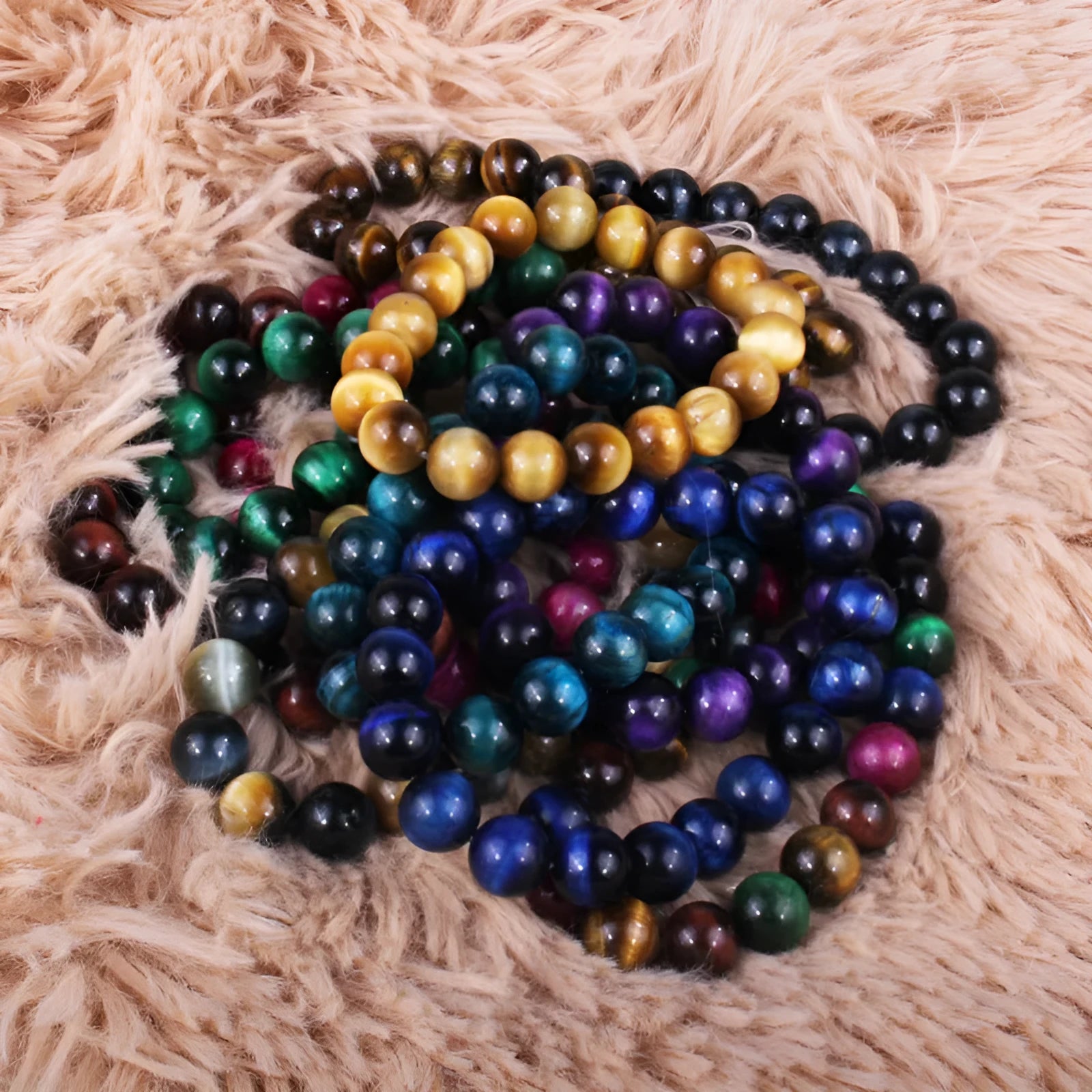 Natural tiger eye crystal bracelet with round beads in various colours on a wrist.