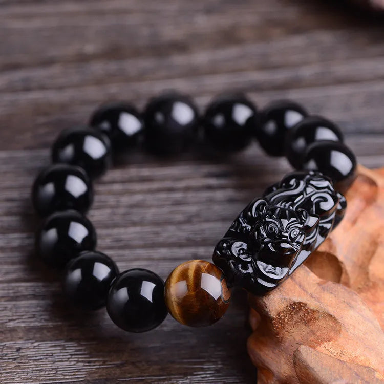 Natural obsidian carved Pi Xiu bracelet with black beads on a cord, gift box and bag visible