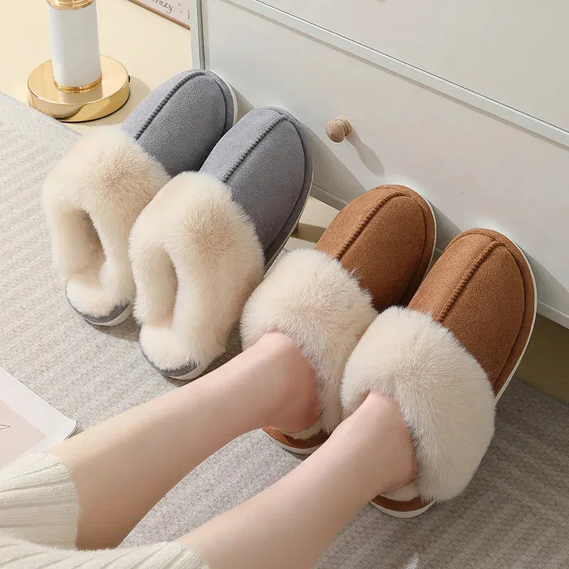 A pair of brown plush winter slippers with a round toe, flat heel, and non-slip PVC sole.
