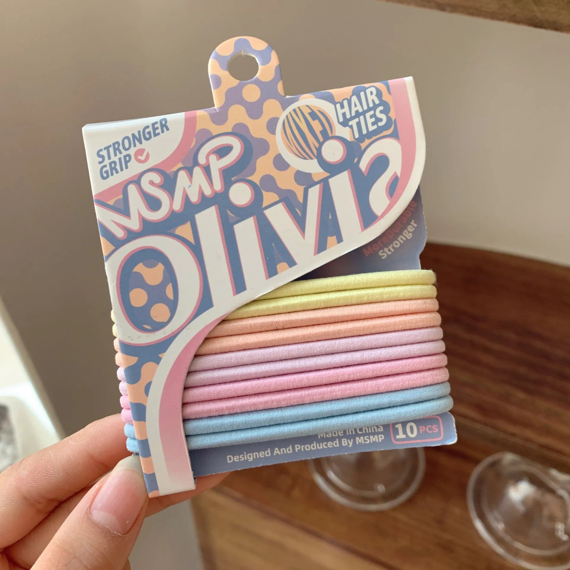 Assorted candy colour elastic hair bands with a braided design, shown holding a ponytail.
